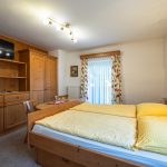 Doppelbett mit gelber Bettwäsche im Gästehaus